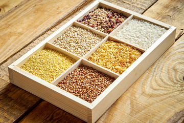 different, colorful types of groats in a wooden square box