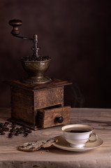 Antique coffee grinder with coffee cup