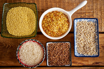 top view of several types of porridge in different bowls on an old wooden table