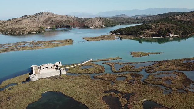 360 POI drone view of Ali Pasha Castle in Butrint (Saranda, South Albania, Albanian Riviera).  Beautiful unique castle sitting in a lagoon - 4k