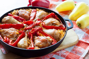Chicken thighs and legs baked over a bed of rice and red bell pepper