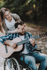 Happy Young Woman and Disabled Man with Guitar