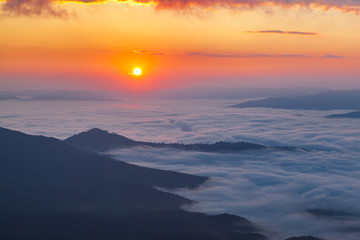Fototapeta na wymiar Sunrise over mist-covered valley. Golden hour in the mountains