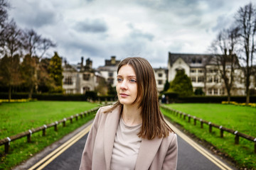 Elegant casual beautiful English Lady portrait in front of Manor Type Building in UK