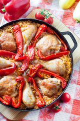 Chicken thighs and legs baked over a bed of rice and red bell pepper