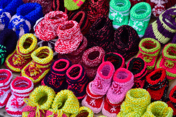 Small colored baby slippers. - obrazy, fototapety, plakaty