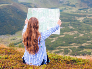 Girl reading a map in the mountains