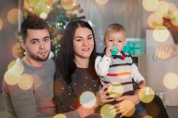 Happy family of three with little boy o  Christmas with decorations