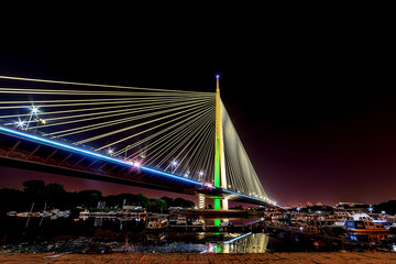 Belgrade, Serbia - 20 June, 2018: Side view of Ada bridge at night with reflection over Belgrade marina on Sava river