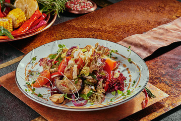 salad with grilled vegetables and soy sprouts on a white plate on a copper background. close-up