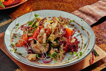 salad with grilled vegetables and soy sprouts on a white plate on a copper background. close-up