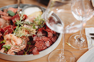 Food tray with delicious salami, pieces of sliced ham, sausage, tomatoes, salad and vegetable - Meat platter with selection - Cutting sausage and cured meat on a celebratory table