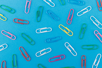 Background made from colored paper clips on the light blue base