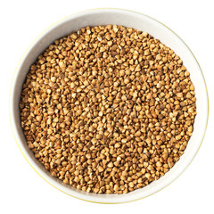 Bowl of Dry Raw Buckwheat Grains Isolated on White Background. Russian Kasha or Uncooked Pseudocereal Buck Wheat with Clipping Path