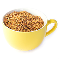 buckwheat grains in a yellow mug, side view, isolated