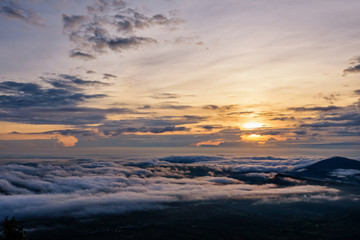 Obraz premium Beautiful nature landscape the sun is above the sea fog that covers the mountains and bright sky during sunrise in the winter at viewpoint of Phu Ruea National Park, Loei province, Thailand.
