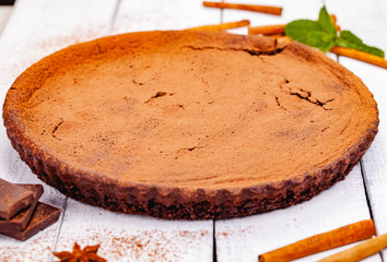 Chocolate pie with cinnamon on wooden rustic table. Close up