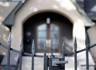 Black iron fence closeup in front of house