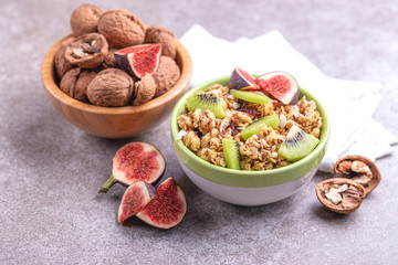 Bowl of homemade granola with fresh bananas and figs