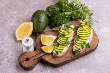 Avocado toasts and ingredients on gray slate background