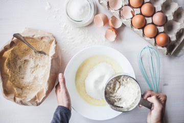 woman preparing the dough, sifting wheat flour in a bowl.selective focus
