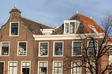 Typical classic Dutch facades of canal houses in The Netherlands against a blue sky on a sunny day at sunset