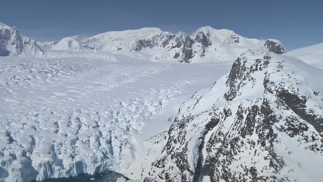 Aerial Flight Over Antarctica Snow Covered Mountains, Polar Ocean. Amazing Drone Overview Of White Winter Landscape. Exotic Travel To Antarctic Wilderness. Beauty Of Virgin Nature. 4k Footage.