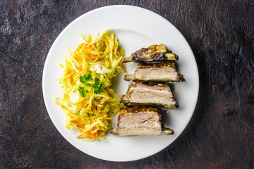 Smoked Roasted pork ribs on plate with cole slaw. Traditional american BBQ food.
