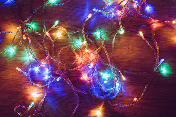 Colorful christmas lights on a wooden background