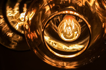 classic edison bulb in a transparent glass ceiling on a black background