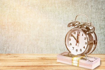 Yellow retro alarm clock on wooden table and wall background