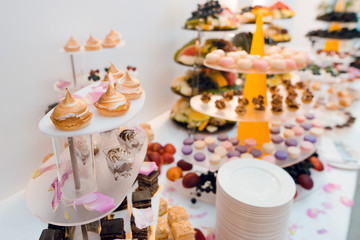 Beautiful candy bar on wedding ceremony. Different tasty sweet desserts on the table background.