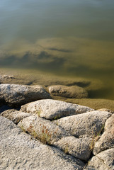 7515154 River with a rocky shore. Texture with water and granite