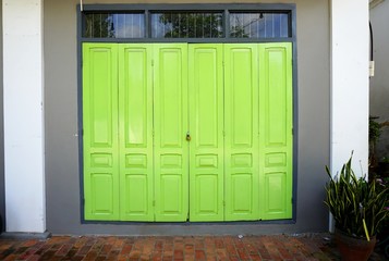 Brilliant chartreuse green doors in a gray and white wall with glass transom above