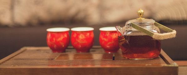 Chinese tea ceremony, Puer  in assortment, Ceramic glass teapot for brewing with tea bowls on a bamboo table