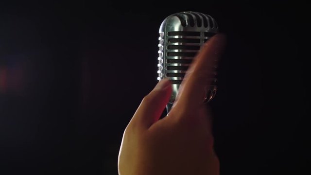 Close up of a finger knocking against a vintage microphone, Shot in 4K 60 fps.