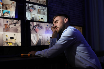 Male security guard sleeping at workplace indoors