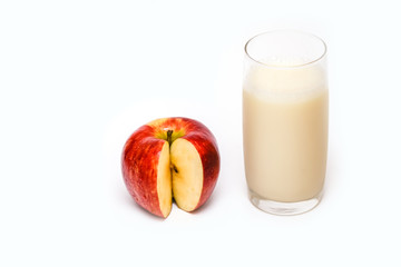 Glass of apple juice next to a tasty apple.
