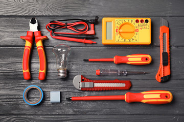 Flat lay composition with electrician's tools on wooden background