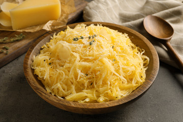 Bowl with cooked spaghetti squash on gray table