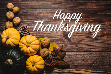 Happy Thanksgiving Day with pumpkin and nut on wooden table