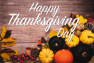 Happy Thanksgiving Day with pumpkin and nut on wooden table