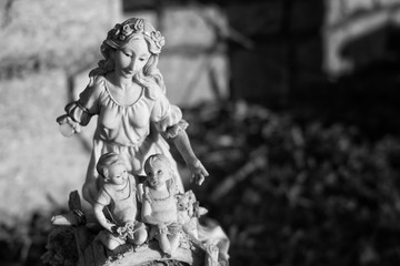 Black and white image of a statue in a cemetery.