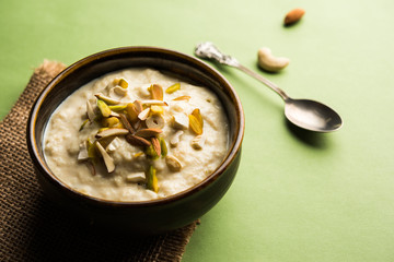 Sweet Rabdi or Lachha Rabri or basundi, made with pure milk garnished with dry fruits. Served in a bowl over moody background. Selective focus