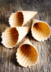 Sweet wafer cone for ice cream on wooden background.