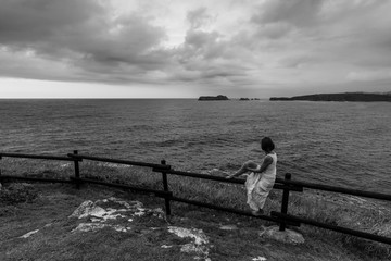 Fototapeta premium Mujer mirando el mar en Suances, Cantabria, España