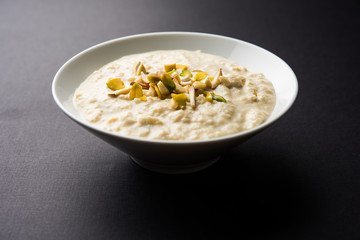 Sweet Rabdi or Lachha Rabri or basundi, made with pure milk garnished with dry fruits. Served in a bowl over moody background. Selective focus