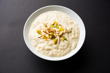 Sweet Rabdi or Lachha Rabri or basundi, made with pure milk garnished with dry fruits. Served in a bowl over moody background. Selective focus