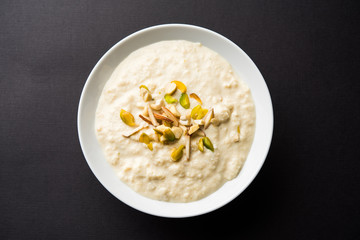 Sweet Rabdi or Lachha Rabri or basundi, made with pure milk garnished with dry fruits. Served in a bowl over moody background. Selective focus