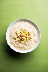Sweet Rabdi or Lachha Rabri or basundi, made with pure milk garnished with dry fruits. Served in a bowl over moody background. Selective focus